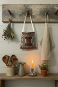 Primitive antique log cabin quilt peg hanger styled in a cozy everyday farmhouse kitchen scene with dried herbs, linen apron, and stoneware accents